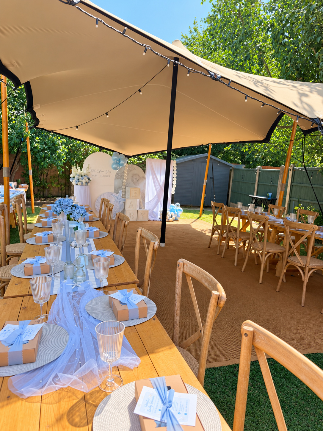 Wedding breakfast tables set under a stretch tent in the countryside