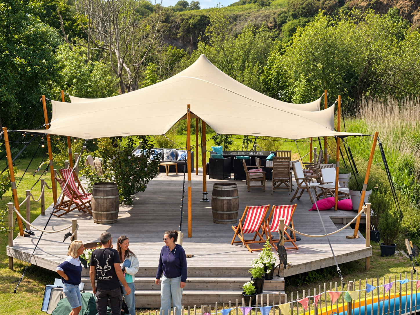 Stretch tent shading a riverside pub garden with barrels and deckchairs